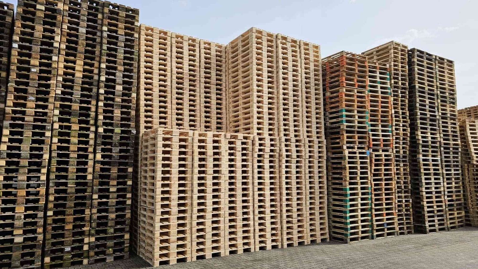 Stosy palet drewnianych na placu produkcyjnym